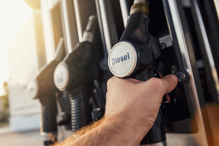 man holding diesel pump nozzle