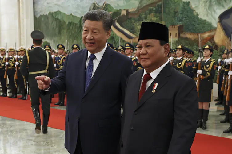 Two men in suits chat.