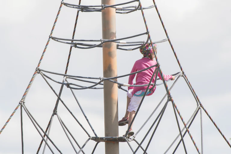 A child on a climbing structure.