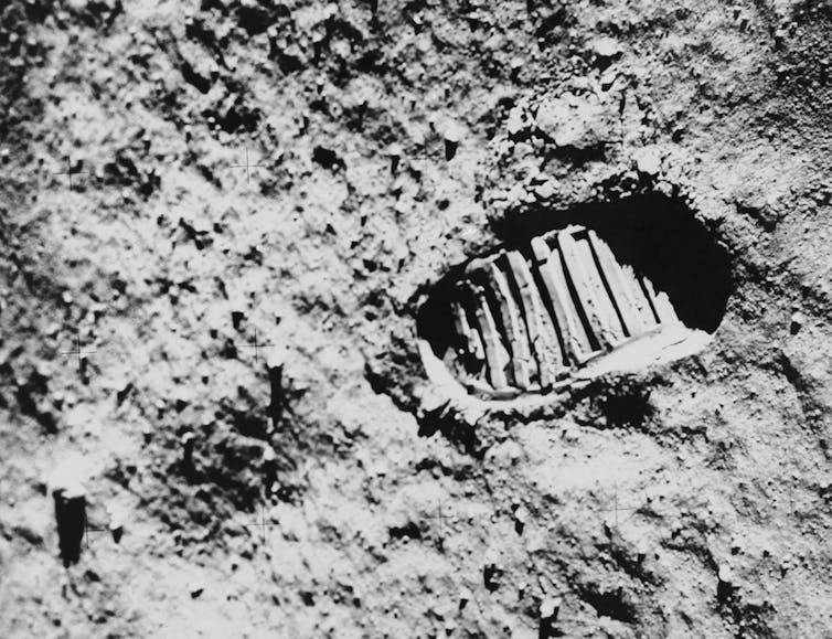A bootprint on the rocky lunar surface.