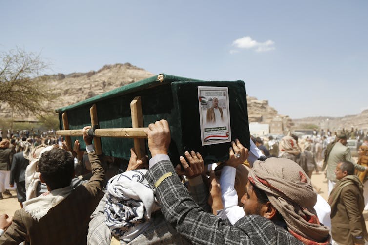People carry a coffin.