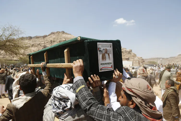 People carry a coffin.