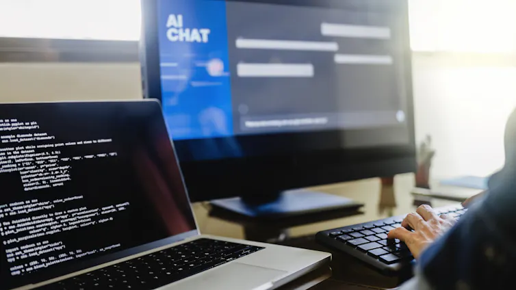 A person working on a desktop computer displaying the words AI chat