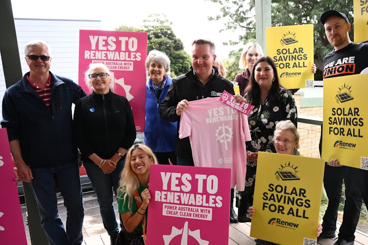 people holding pro-renewables signs