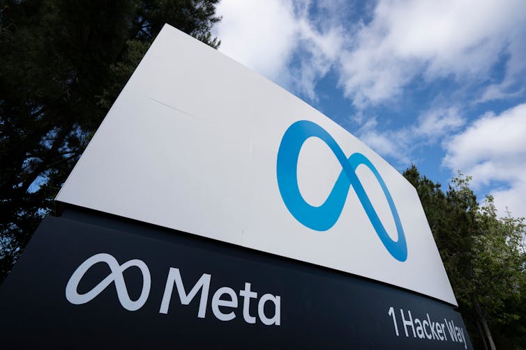 A large blue and white sign featuring Meta's logo.