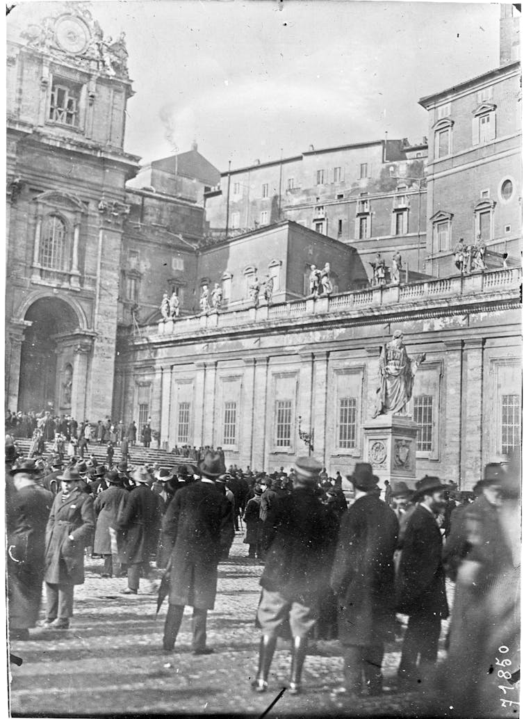 Fotografia em preto e branco: uma multidão em uma praça.