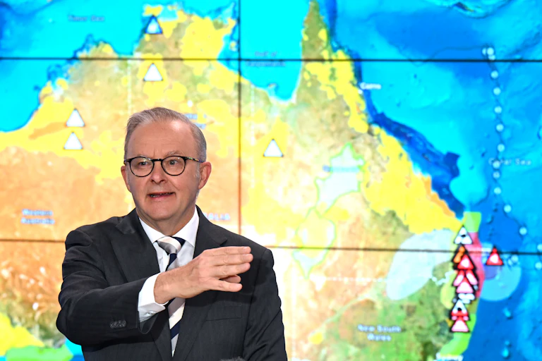 A man points in front of a weather map.