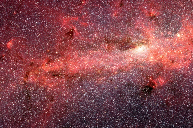 An image of deep space, awash in stars and a bright red tinge.
