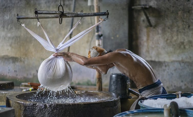 Un ouvrier presse le soja pour en extraire l’eau, dans le village de Krian (Sidoarjo), dans l'est de Java, connu pour ses usines de fabrication de tofu.