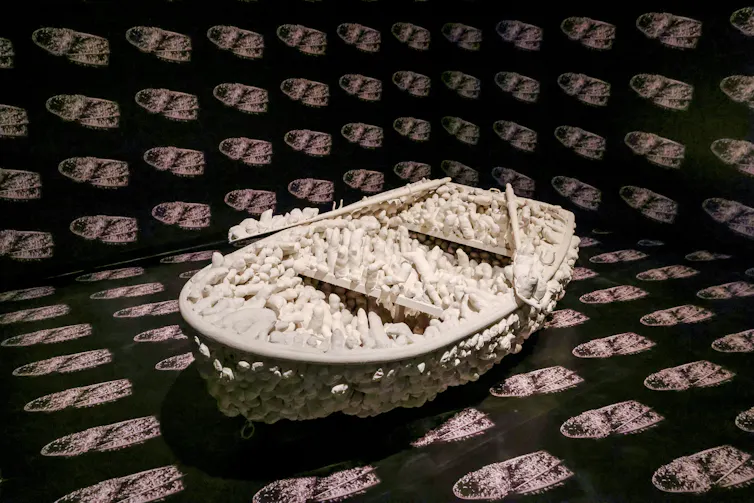 A boat with white blobby figures growing out of it.