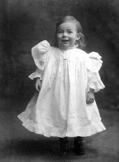 a boy in a white dress