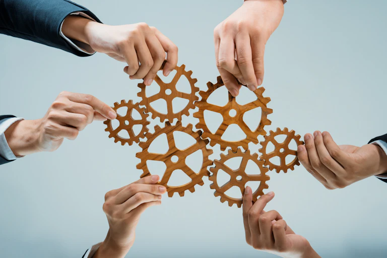 Business team joining cogwheel in circular system