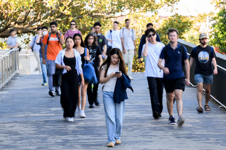 Students walk on a bridge at Sydney University.
