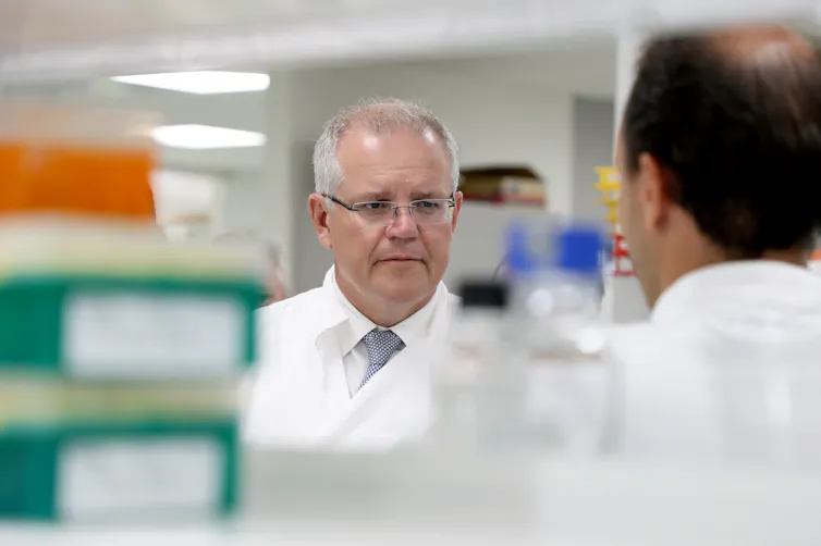 Former Prime Minister Scott Morrison in a white lab coat.