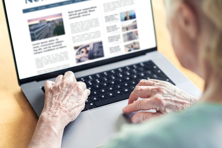 Photo of a person reading news on a computer.