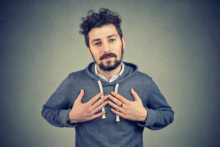 Man puts hands on chest apologetically