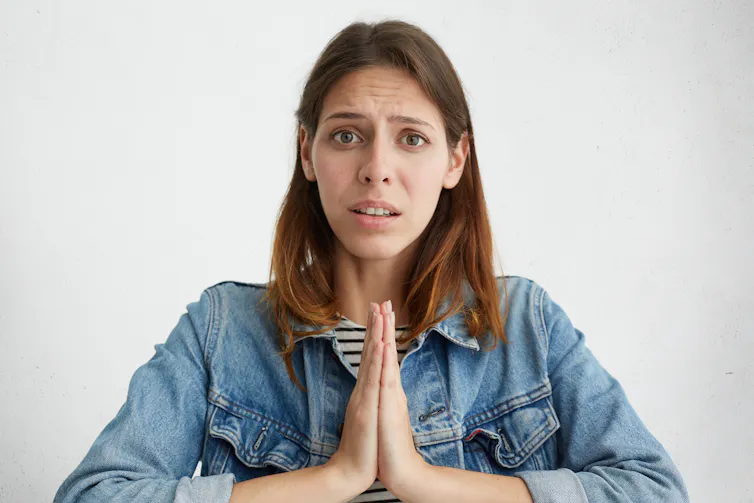 Woman looks at camera with regretful expression
