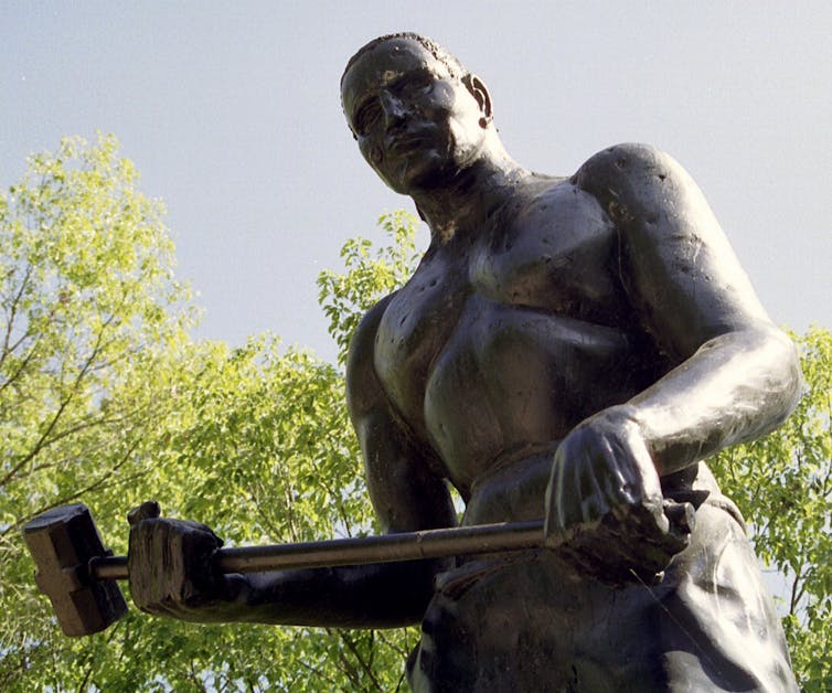 A statue of a man holding a hammer, depicting African American folk hero John Henry