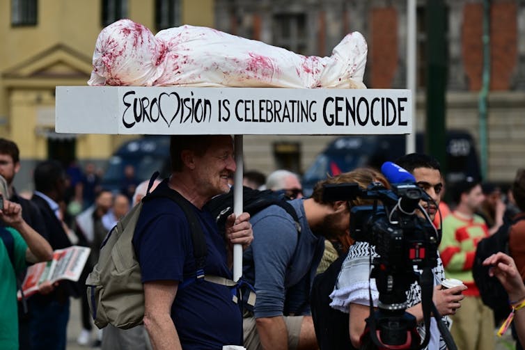 Un hombre sujeta una pancarta que dice, en inglés, 'Eurovisión está celebrando el genocidio'.