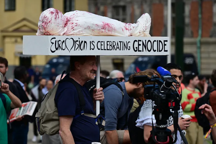 Un hombre sujeta una pancarta que dice, en inglés, 'Eurovisión está celebrando el genocidio'.