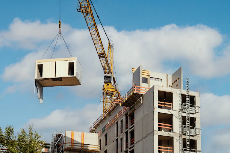 A crane lifting a prefabricated house