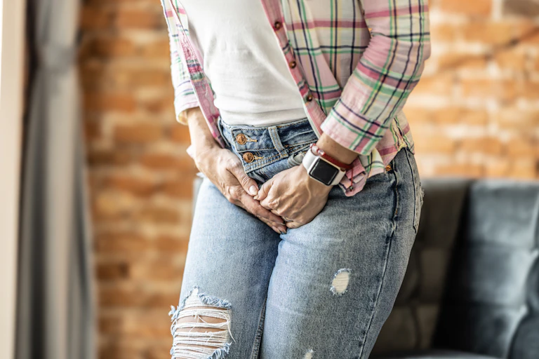 View of a person clutching their groin area as if in pain.