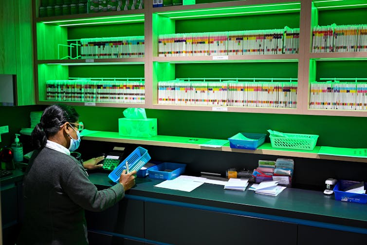 A pharmacists prepares scripts at National Chemist pharmacy
