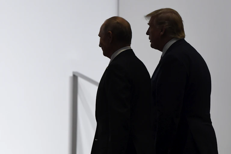 Two men walk in silhouette.