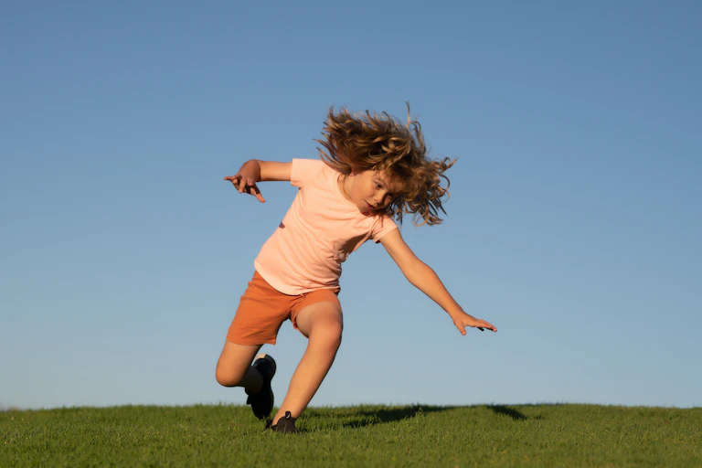 Child falling on grass in summer