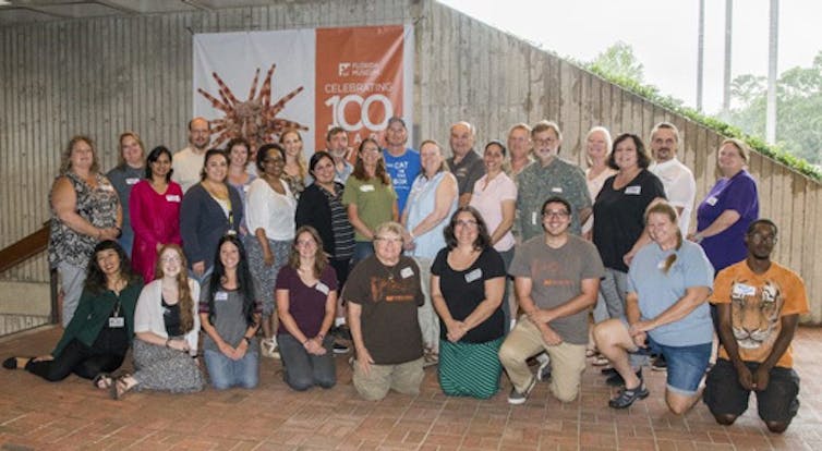 A group of people standing and kneeling outdoors.