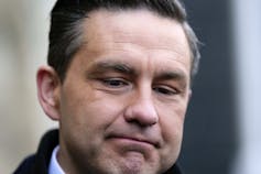 Primer plano de un hombre de patas oscuras con una expresión de ovejas en la cara.