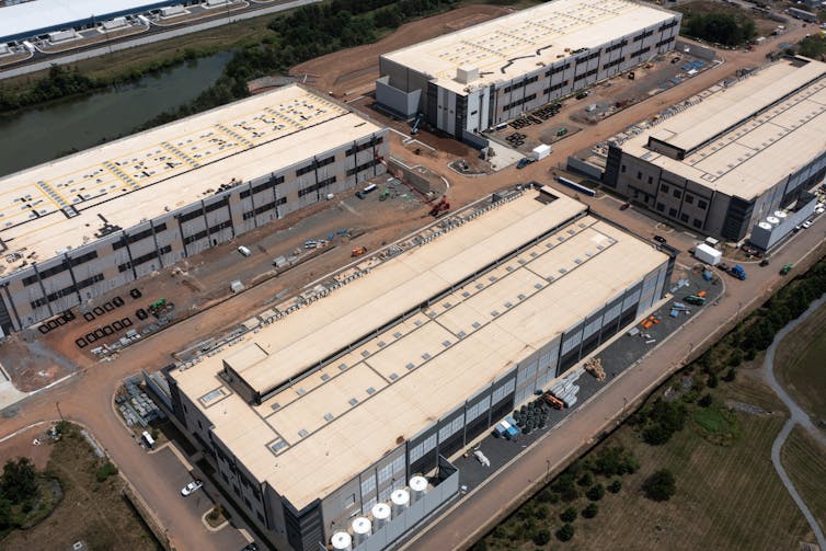 Aerial view of four massive rectangular industrial-looking buildings