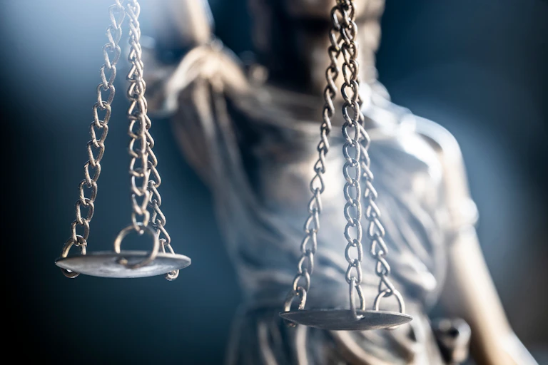 Cropped image of Lady Justice statue focused on scales.