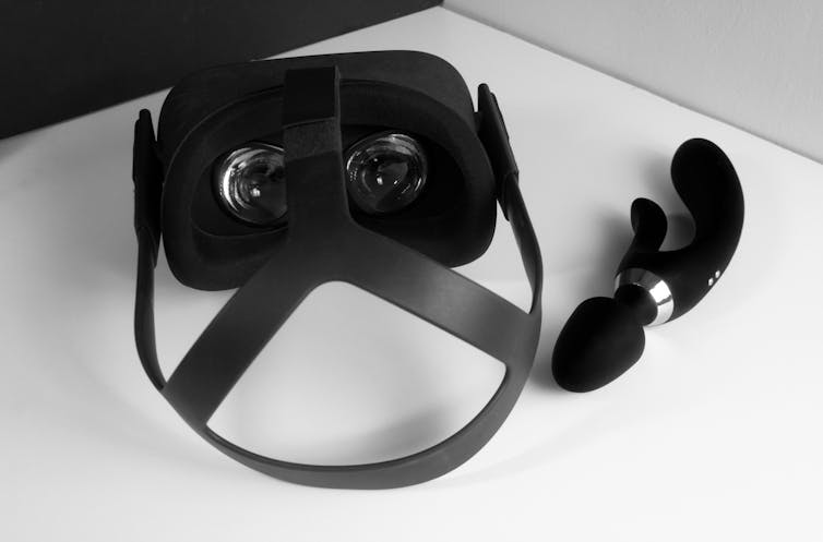 Auriculares VR en la mesa al lado del juguete sexual