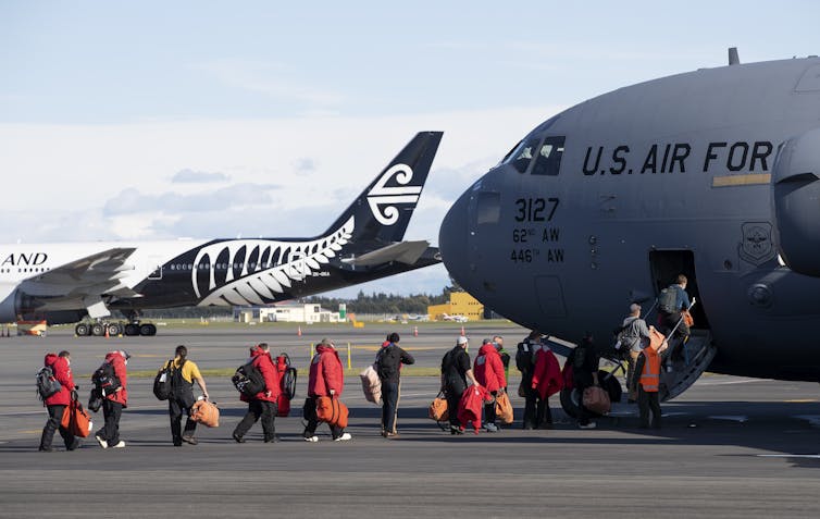 People line up to board a plane marked 'US Air Force'.