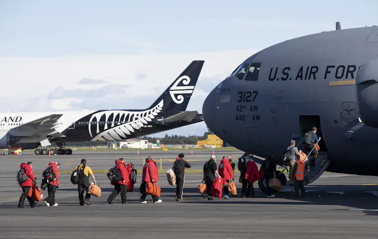 People line up to board a plane marked 'US Air Force'.