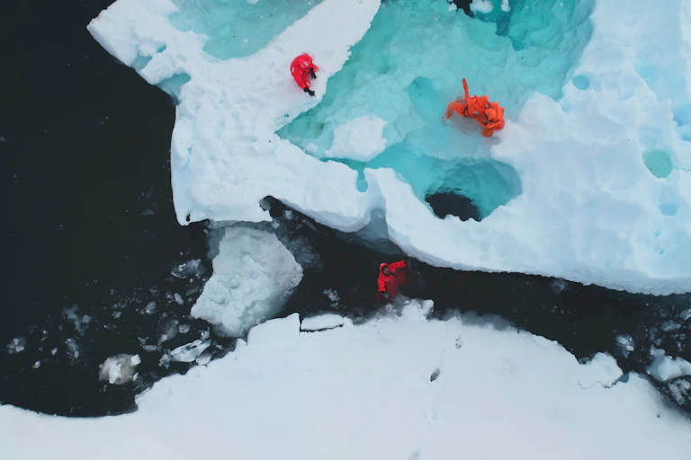 People in red clothing on ice.
