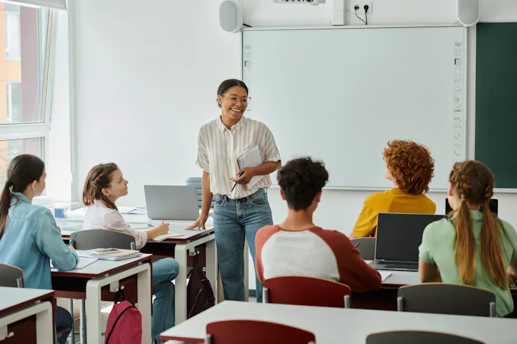 Teacher smiling at class of teenagers