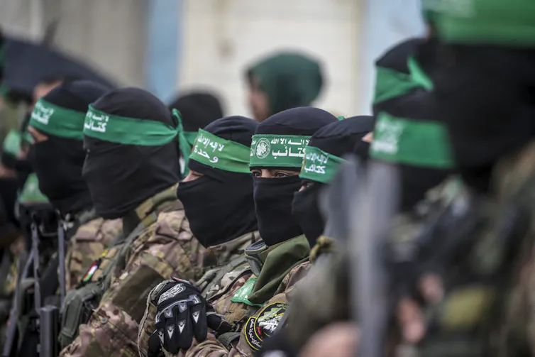Hamas fighters stand guard during the handover of three Israeli hostages in February 2025.