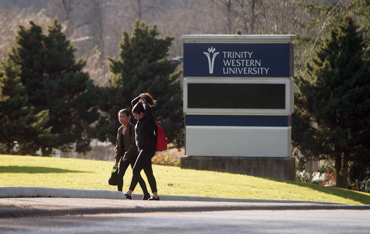 Los estudiantes caminan por el campus con un día soleado.