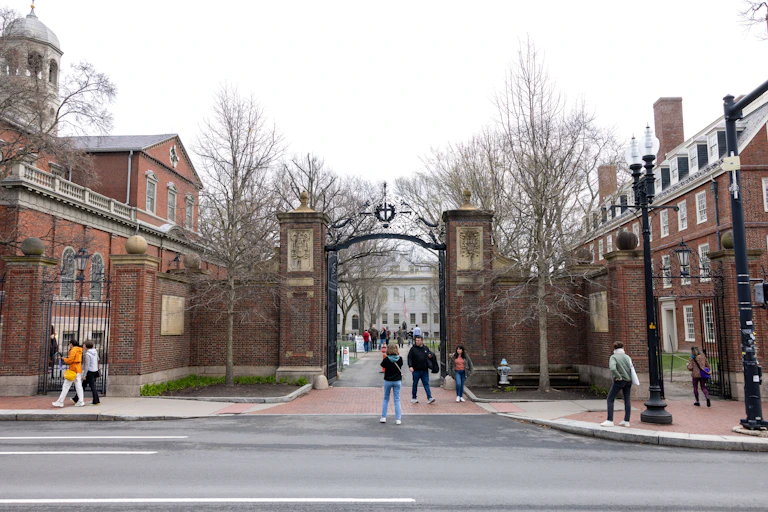 Tourists mill about in front of the main gate to Harvard Yard.
