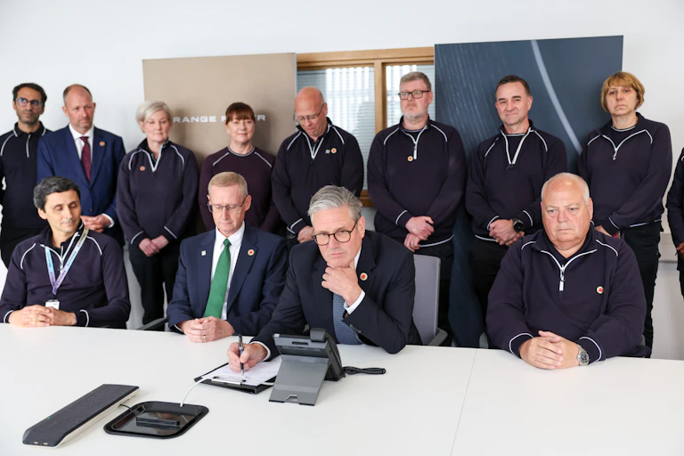 keir starmer on a phone call to donald trump surrounded by workers from jaguar land rover