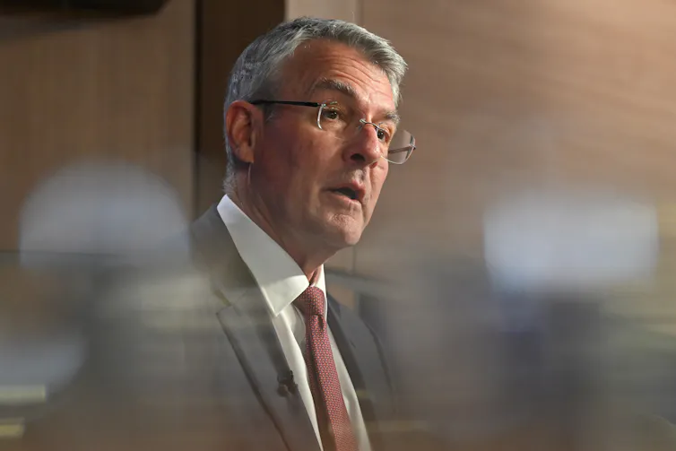 Mark Dreyfus speaks behind some blurred lights.