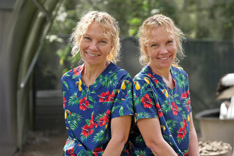 Paula and Bridgette Powers, two identical twins wearing colourful veterinarian scrubs.