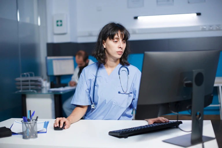 Health worker at desk in front of computer screen