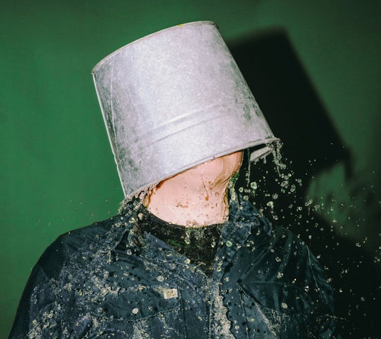 personne avec seau d’eau renversé sur la tête