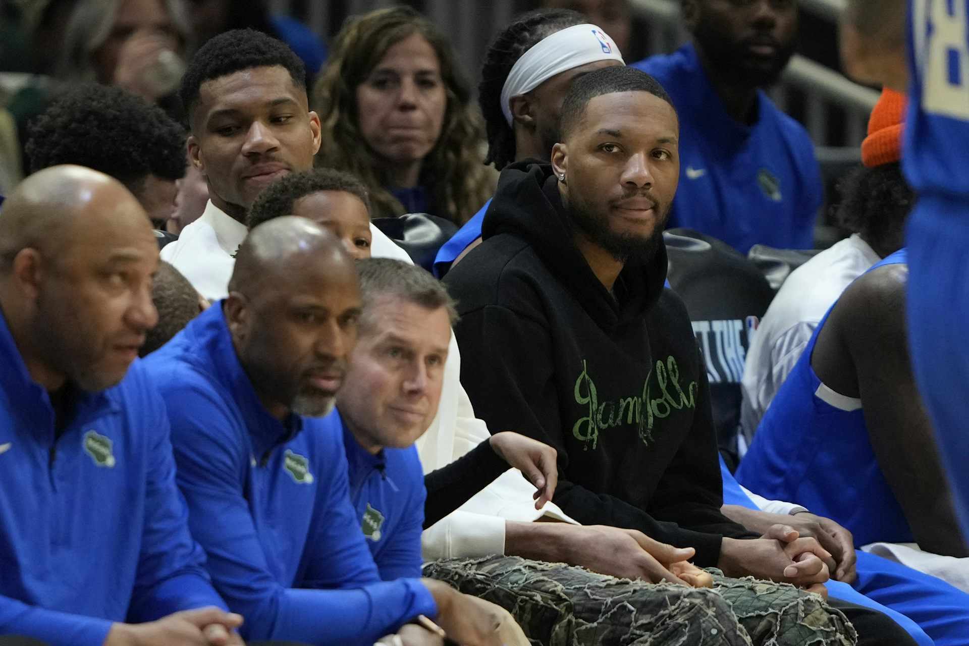 A man in a dark green sweatshirt sitting with others