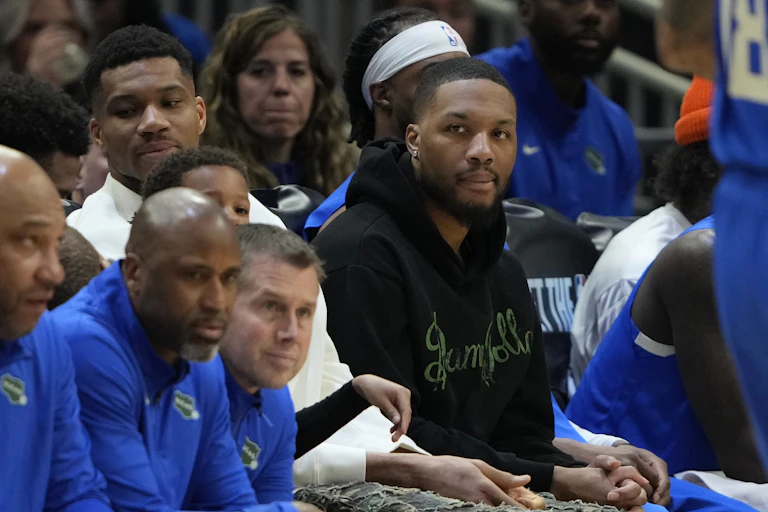 A man in a dark green sweatshirt sitting with others