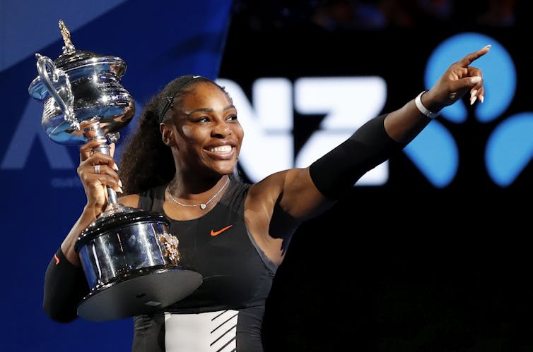 Tratamientos mortales de coagulación, riesgos 1 Serena Williams sosteniendo un gran trofeo, sonriendo y dirigido hacia arriba