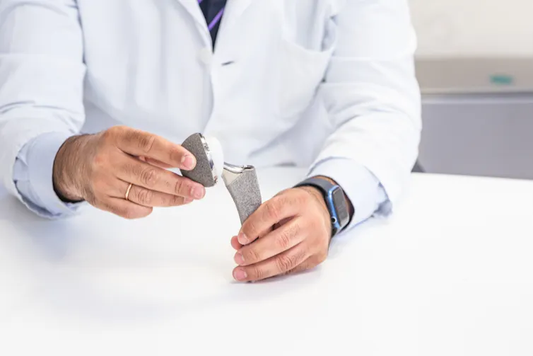 A doctor holding an artificial hip joint.
